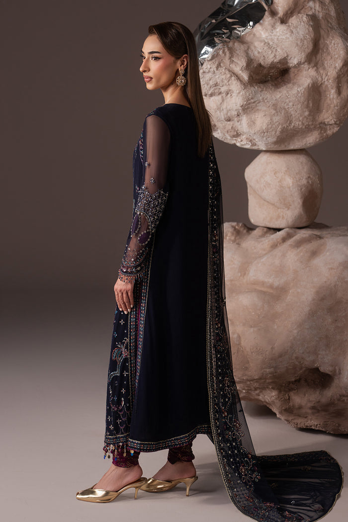 Side view of Alishma highlighting the navy blue Crinkle shirt, sheer embroidered sleeves and contrast churidar pajama.