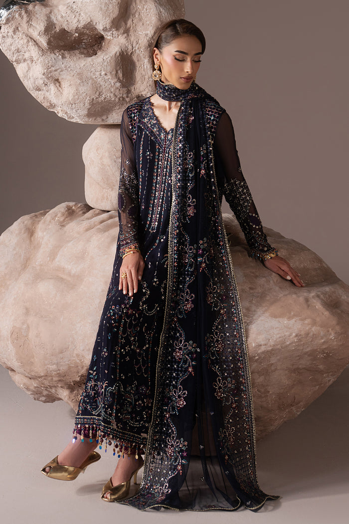 Seated view of Alishma navy blue semi-formal outfit showing the embroidered shirt, Net dupatta and traditional churidar styling.