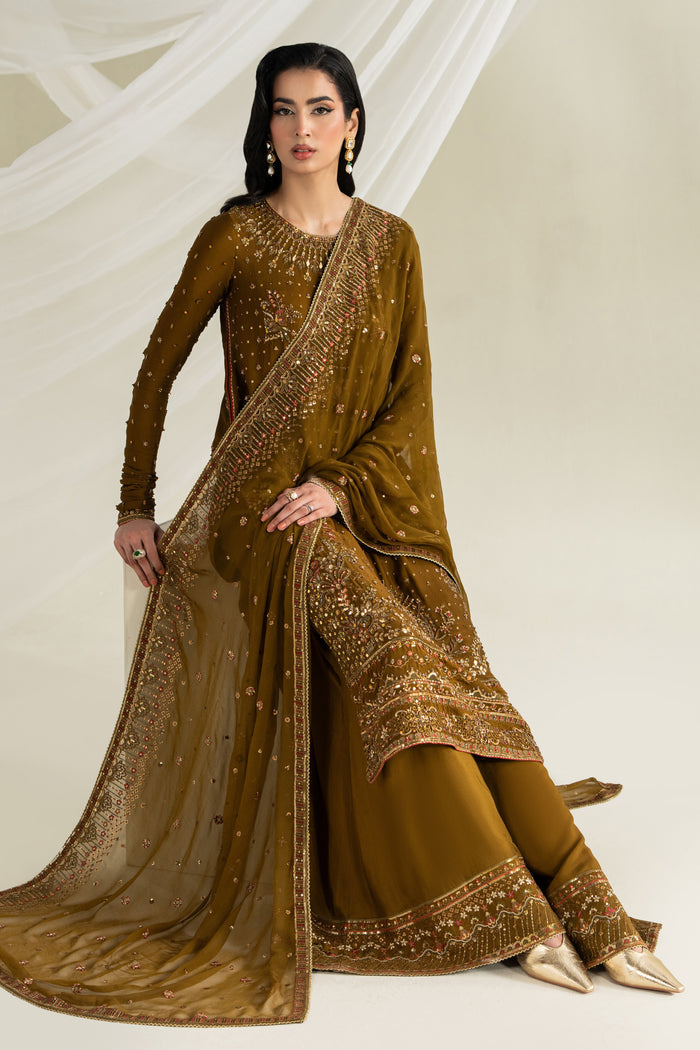 Deep brown formal ready-to-wear outfit with flared trousers and dupatta, seated pose showing full styling for weddings and formal gatherings