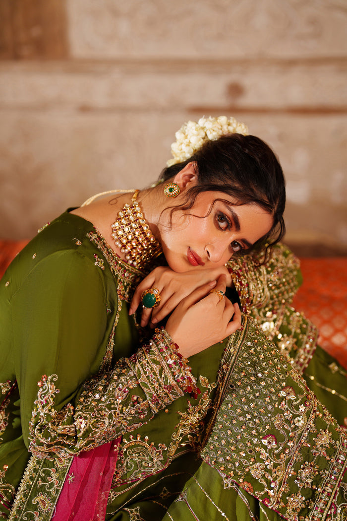 Styled close-up shot of NAQSHI Anadil green formal outfit showing detailed embroidery on sleeves and neckline for wedding and reception events.