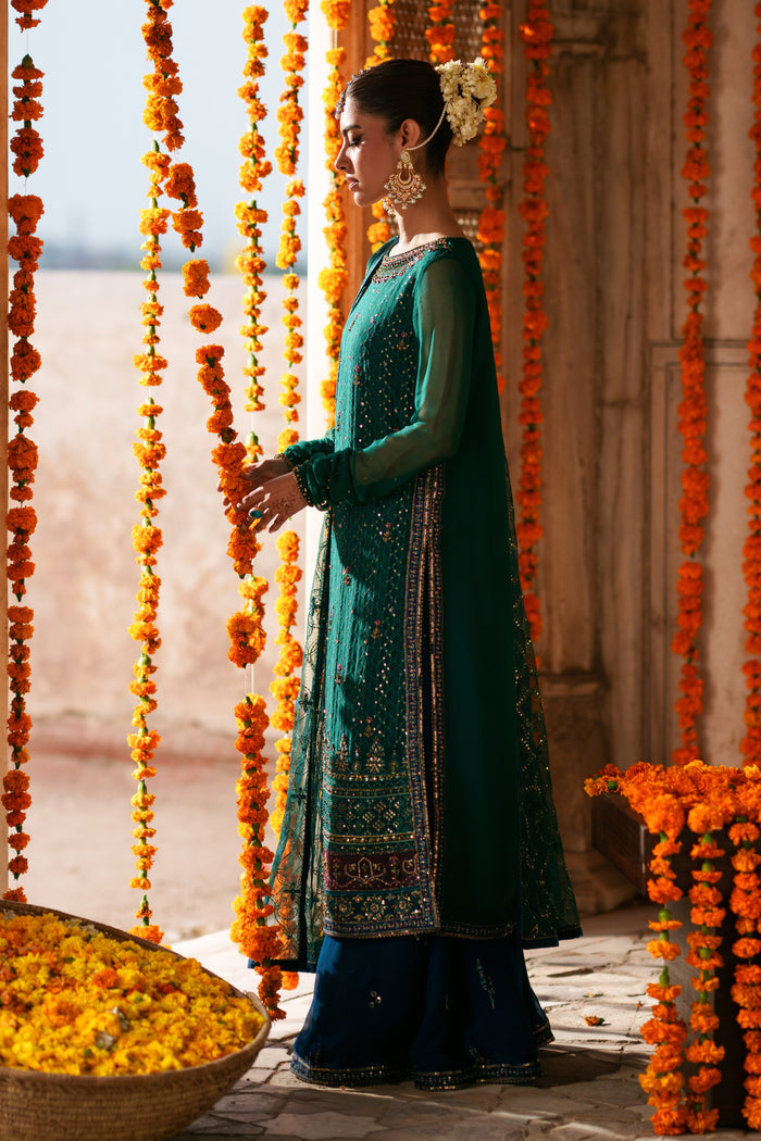 Side view of Anfa green crinkle chiffon semi formal outfit featuring flowing sleeves, blue flary pants and embellished festive detailing