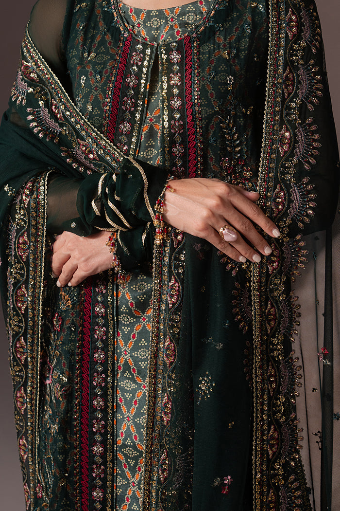 Close-up of Arfiya showing machine embroidery, sequins, contrast trim, goti detailing and printed accents on the green Crinkle gown.