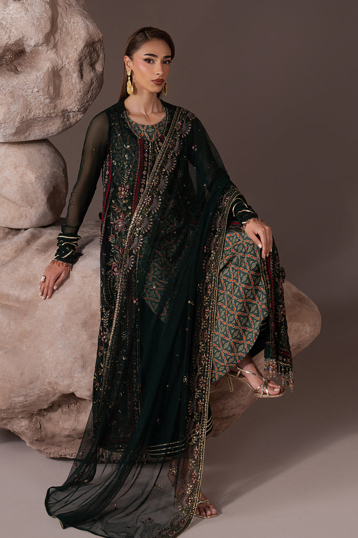 Seated view of Arfiya green semi-formal outfit showing the embroidered gown, digital print inner and draped Net dupatta.