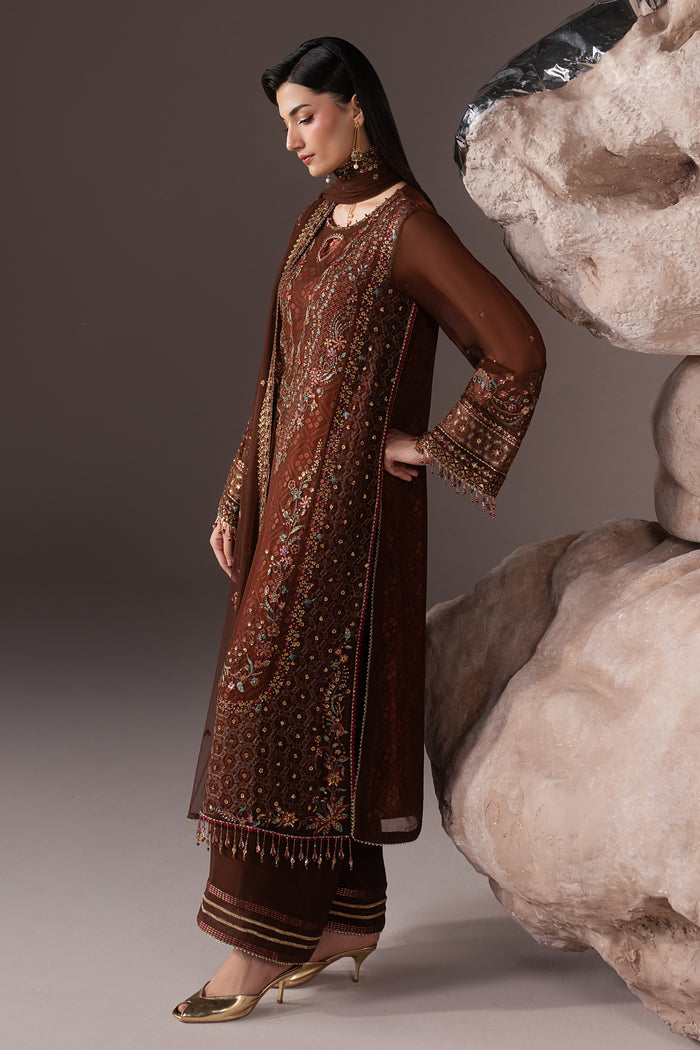 Three-quarter view of Aroob highlighting the chocolate brown Crinkle shirt, culotte trouser and coordinated semi-formal silhouette.