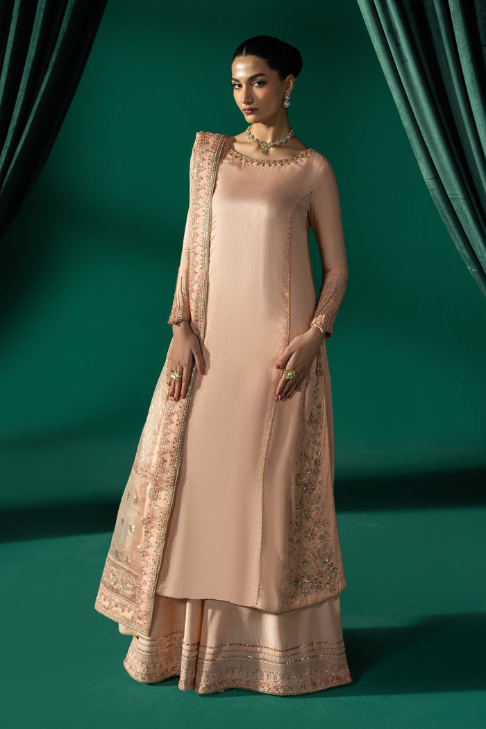 Azba peach 3-piece semi-formal outfit with Indian Raw Silk A-line frock, wide PK Raw Silk sharara and Organza Barosha dupatta in a full front view.