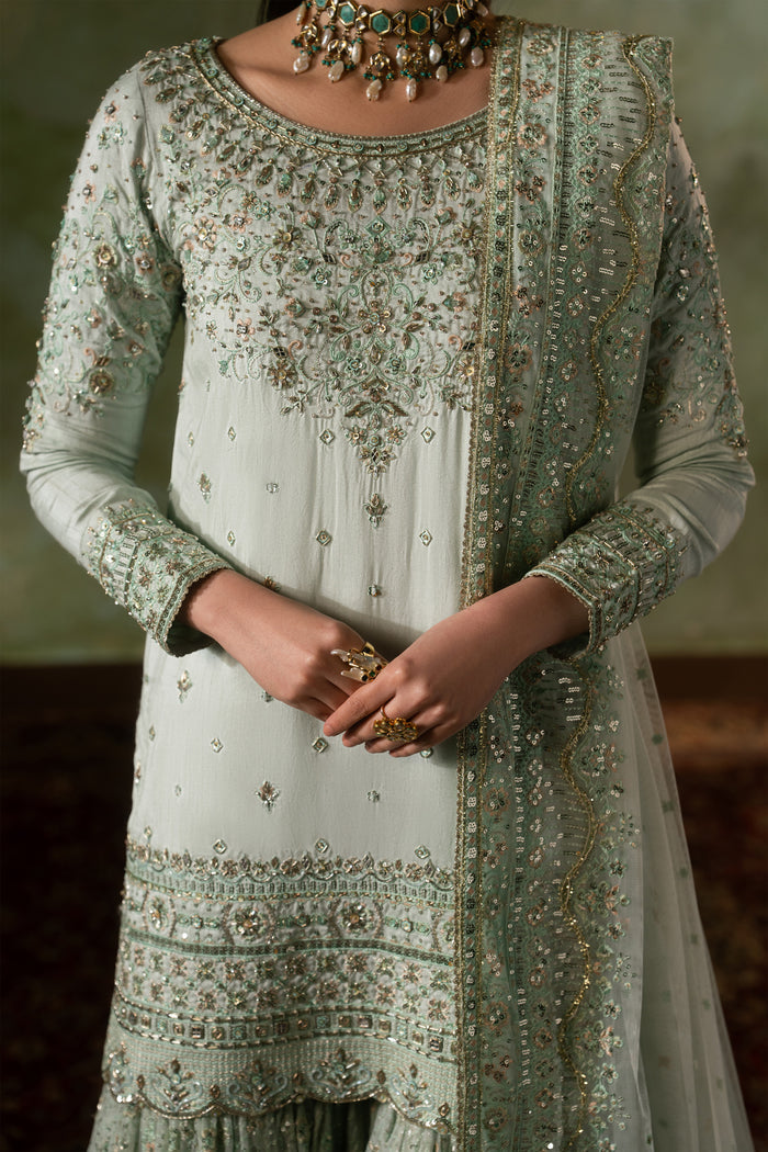 Close up of Azeyma raw silk shirt embroidery and neckline detailing in pale pistachio color, neat stitching formal Nikkah wear for women.