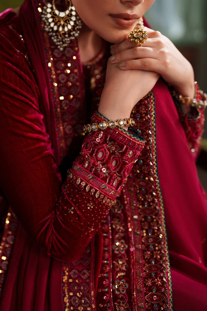 Close-up detail of NAQSHI deep red formal dress showing embroidery on neckline and sleeves