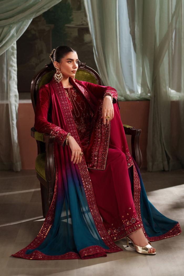 Seated styling view of NAQSHI deep red ready-to-wear formal outfit with embroidered shirt and matching trousers
