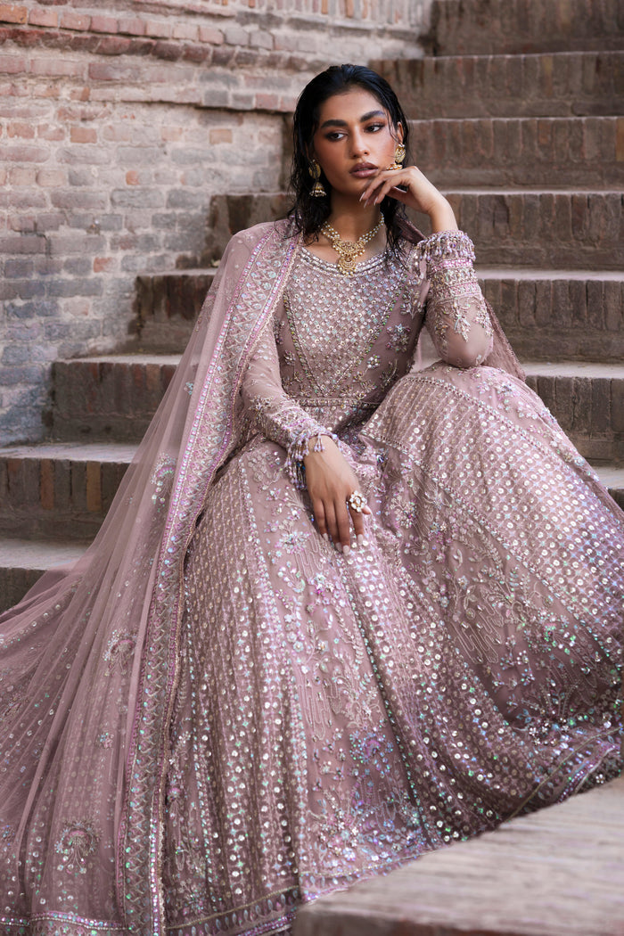 Blaithin tea pink Net maxi seated pose showing wide flare and floral lower-panel detailing.