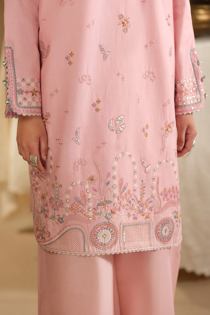 Close up of Dana shirt wide embroidered hem border and small motif detailing on pink Pima lawn fabric