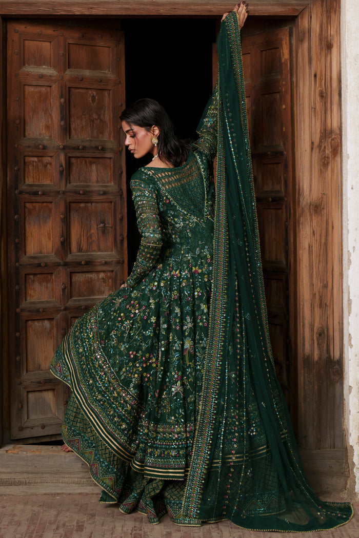 Etta deep green evening maxi side pose highlighting embroidery, sequins and detailed hem border.