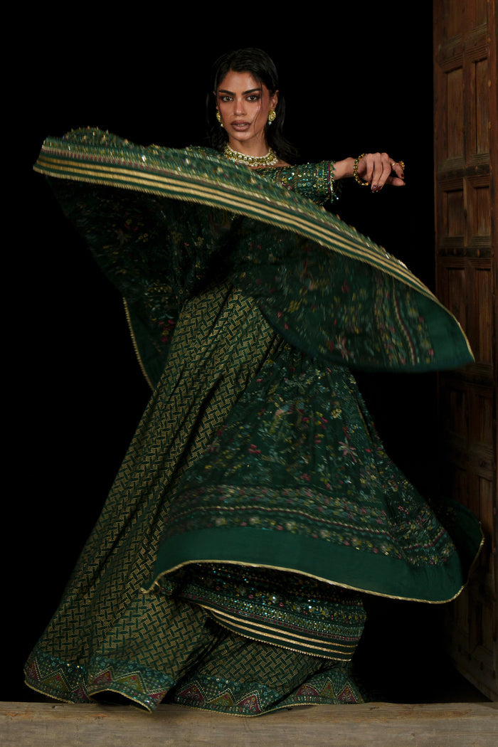 Etta deep green Crinkle maxi in motion showing wide panelled flare and layered lower section.