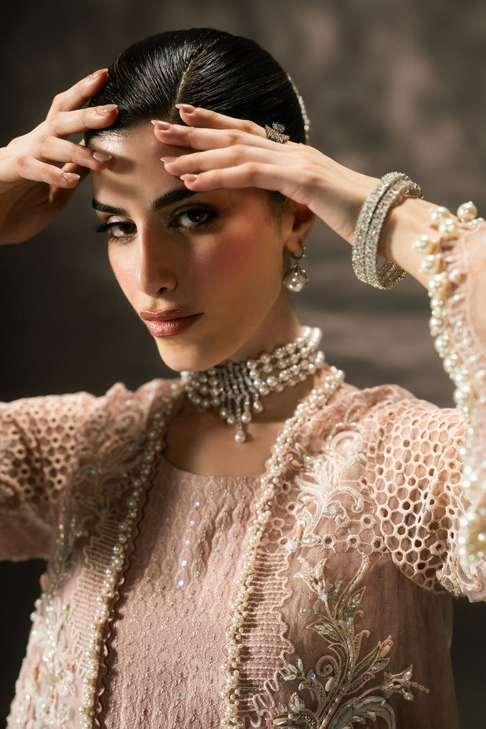 Close-up of Farfalle showing the embroidered neckline, sequin detailing, cutwork sleeve and delicate pearl-edged finish.