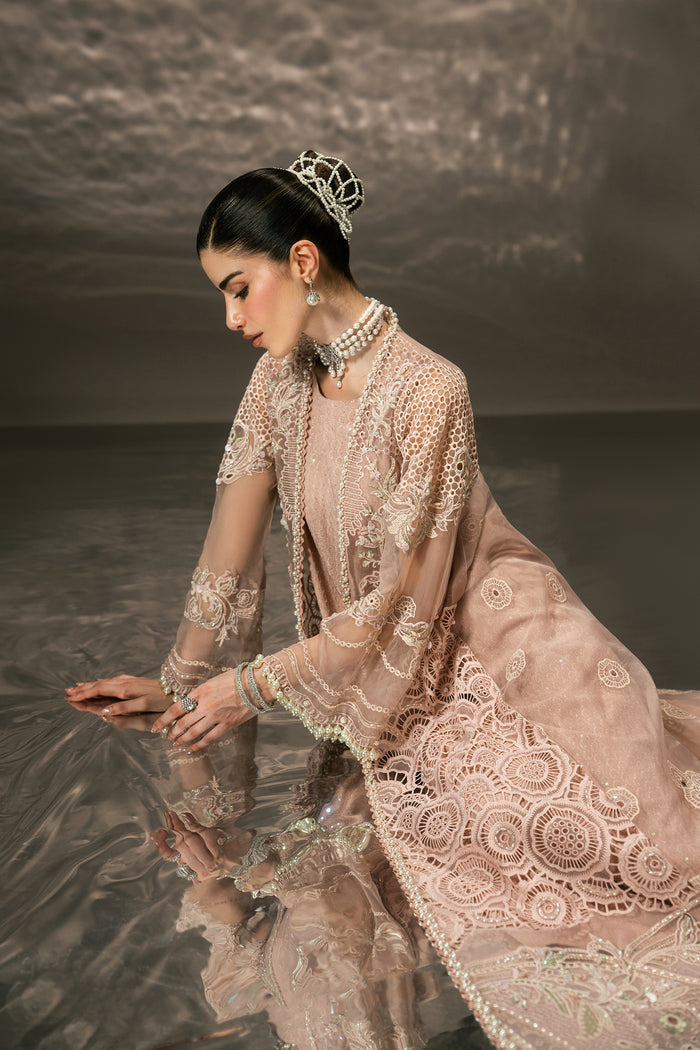Seated profile of Farfalle light peach evening outfit highlighting the sheer Organza layers, embroidery and flowing gown shape.