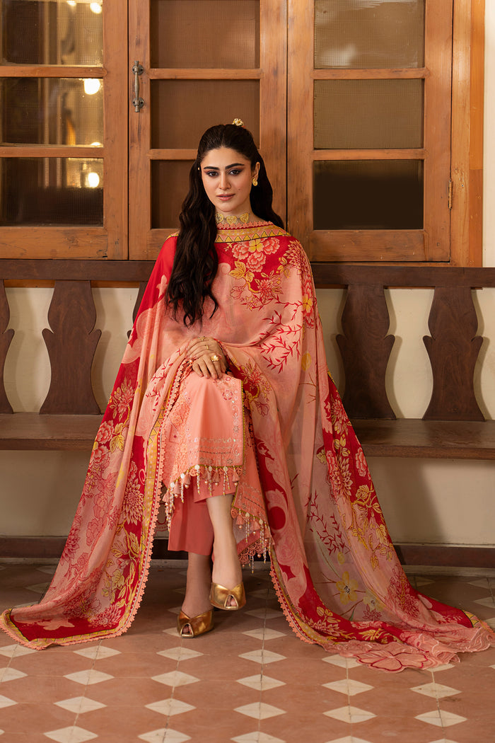 Seated styling shot of NAQSHI Farnood peach casual pret outfit with embroidered lawn shirt, straight trousers and digitally printed dupatta