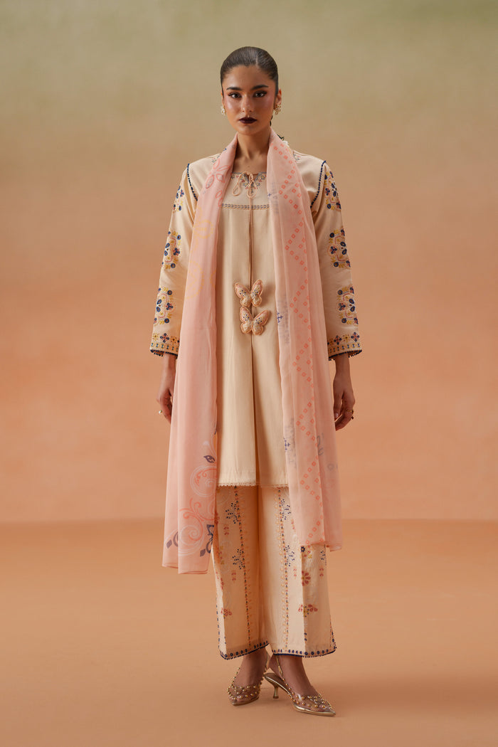 Model wearing Faye light peach embroidered lawn outfit with printed chiffon dupatta and cambric culotte trouser for festive daytime wear.