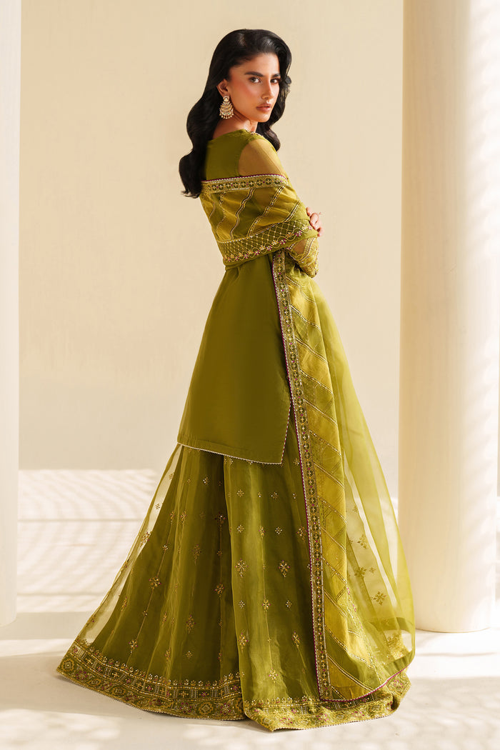 Woman wearing a green traditional outfit with embroidery in a bright setting