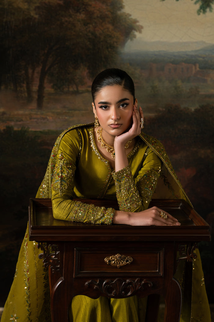 Seated portrait of Ghina in olive green semi-formal wear showing the embroidered frock and softly draped Organza dupatta.