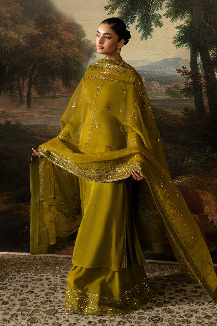 Full-length movement view of Ghina showing the flowing olive green frock, wide PK Raw Silk sharara and embroidered Organza dupatta.