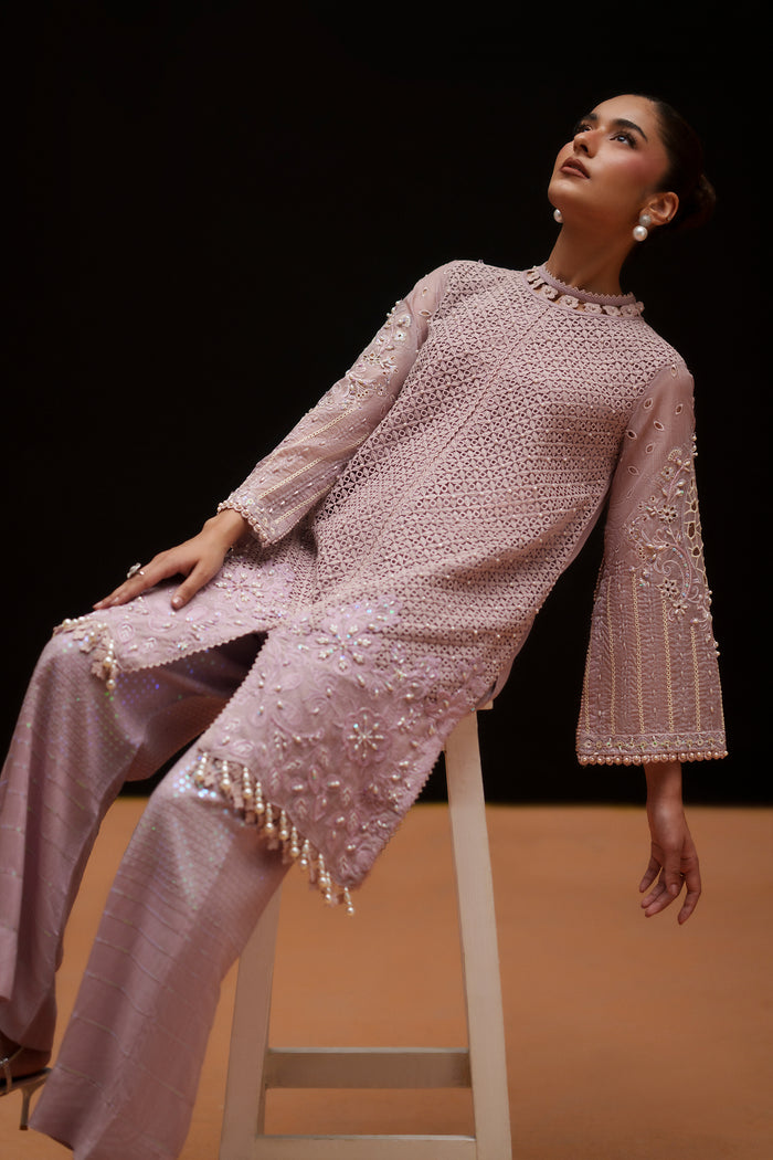 Side seated view of Gigil light purple evening wear showing the flowing sleeves, shirt cutwork and flared trouser shape.