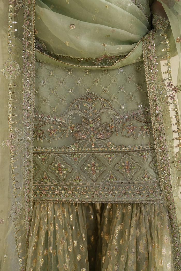 Close-up of NAQSHI sage green dress showing detailed embroidery on fabric and borders