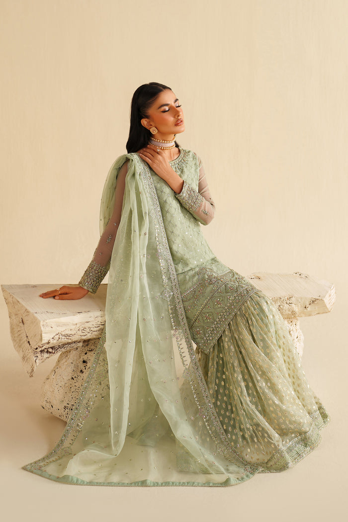 NAQSHI sage green dress shown in motion, displaying wide flare and soft fabric movement