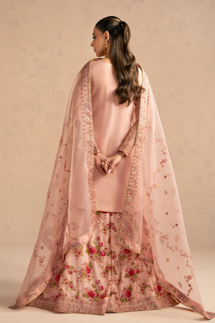 Back view showing flowing dupatta fall and wide flared printed sharara, elegant stitched formal wear.