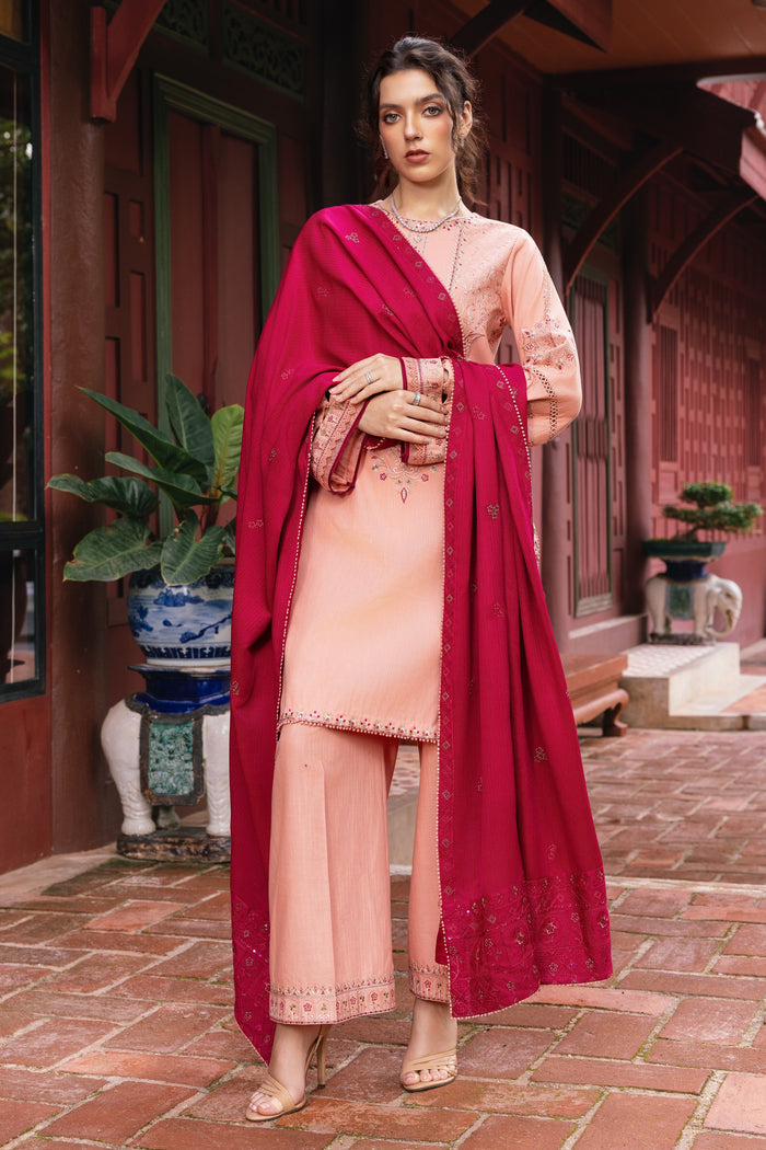 Woman in a traditional outfit with a red dupatta standing in an outdoor setting.