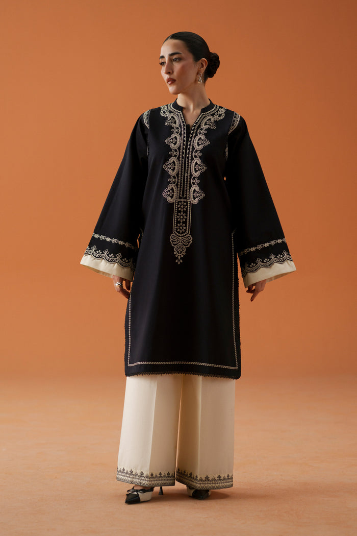 Model wearing Isla black embroidered lawn shirt with wide cambric culotte trousers and printed chiffon dupatta for semi-formal occasion wear.