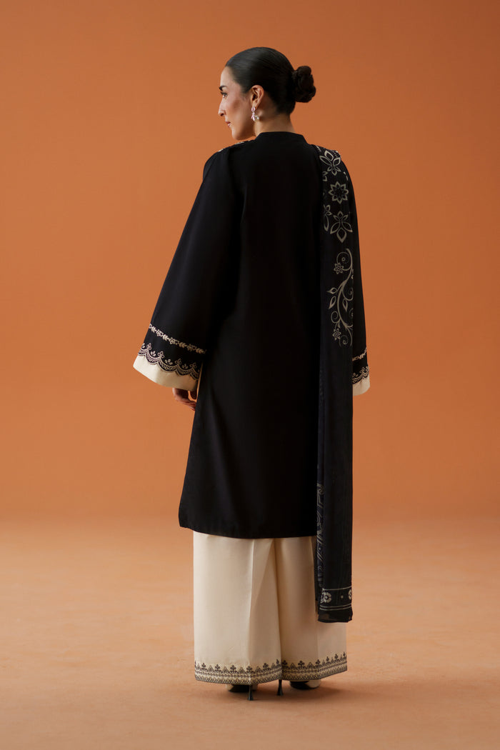 Back view of Isla black 3-piece outfit with long embroidered lawn shirt, relaxed culotte trousers, and printed crinkle chiffon dupatta.