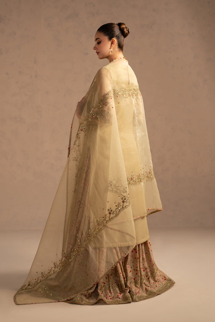 Side walking view highlighting soft fall of dupatta and flared sharara, modest semi formal eastern outfit.