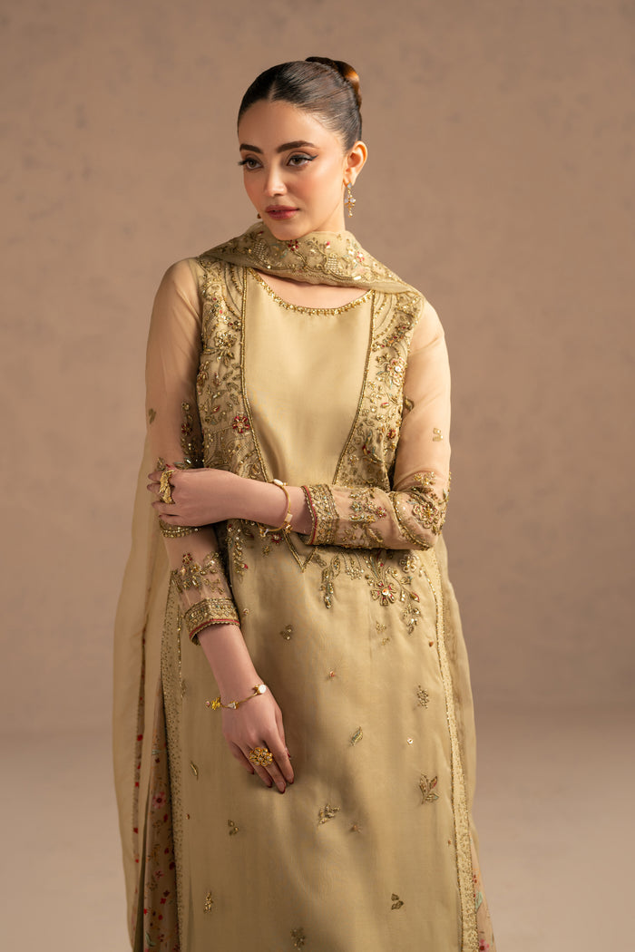 Close portrait focusing on neckline embroidery, sleeve borders and delicate sequin work on soft neutral fabric.