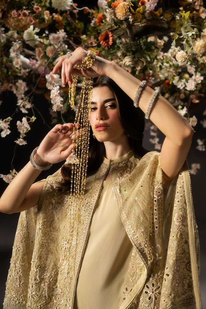 Close-up of Livia pale yellow evening wear showing the neckline, embroidered Organza cape, sequins and flowing slit sleeve detail.