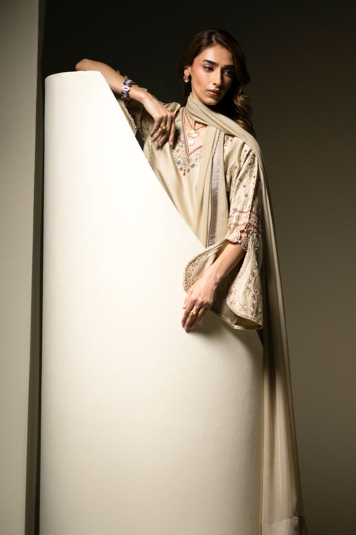 Louisa Dusty Beige outfit styled in profile showing loose embroidered sleeve and long shirt silhouette.