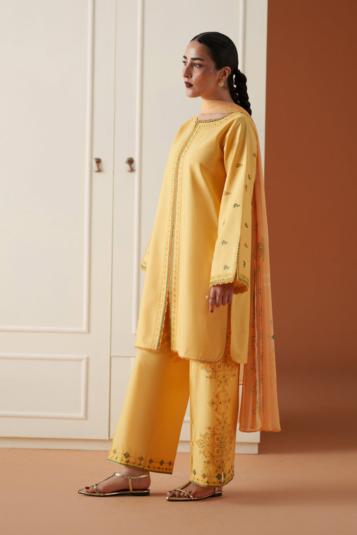 Side view of Mabel yellow embroidered lawn outfit with cambric culotte trouser and printed chiffon dupatta for festive casual wear.