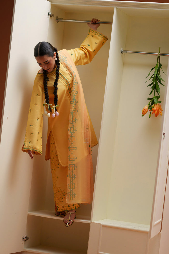 Model wearing Mabel yellow embroidered ready-to-wear outfit with printed chiffon dupatta and relaxed Eastern summer styling.