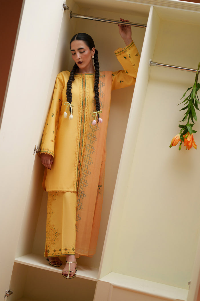 Mirror pose of Mabel yellow casual festive outfit showing embroidered lawn shirt, printed crinkle chiffon dupatta, and culotte trouser.