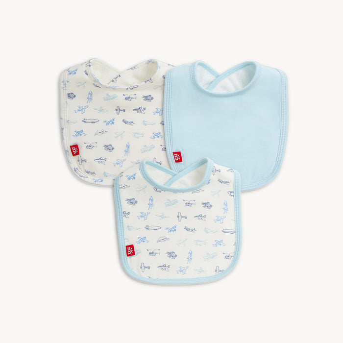 A three-pack of baby bibs featuring one solid light blue bib and two bibs decorated with a blue vintage aircraft print, By Magnetic Me.