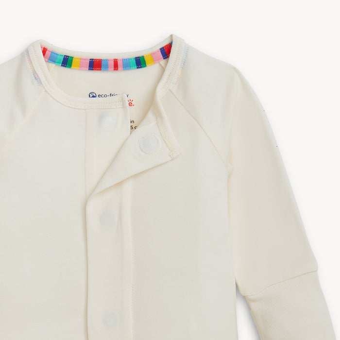 Open magnet in the center of A solid off white long-sleeve convertible coverall romper with a hidden magnetic closure by Magnetic Me.