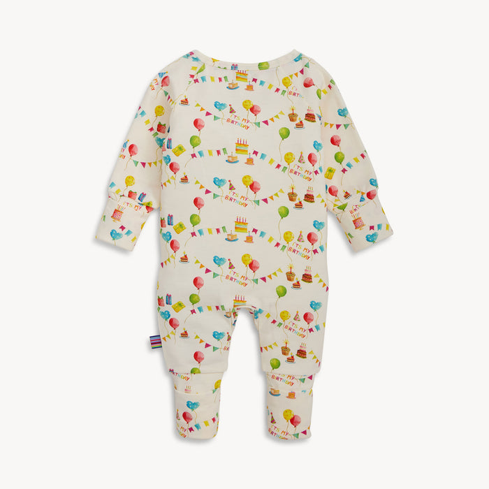 Back of the cream-colored long-sleeved convertible coverall with a watercolor "It's My Birthday" print and hidden magnetic closures that easily swap between footed and footless styles, by Magnetic Me.