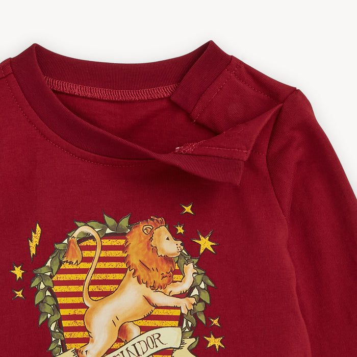 Open magnet on the shoulder of A burgundy long-sleeve t-shirt with hidden shoulder magnets featuring a Gryffindor house crest print with a lion and gold stars, by Magnetic Me for Warner Brothers.
