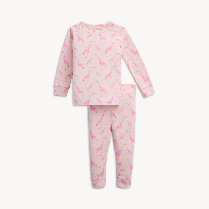 A light pink long-sleeve pajama set featuring an all-over Jolie Giraffe print of pink-toned giraffes and small storks on leafy branches, by Magnetic Me.
