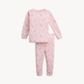 A light pink long-sleeve pajama set featuring an all-over Jolie Giraffe print of pink-toned giraffes and small storks on leafy branches, by Magnetic Me.