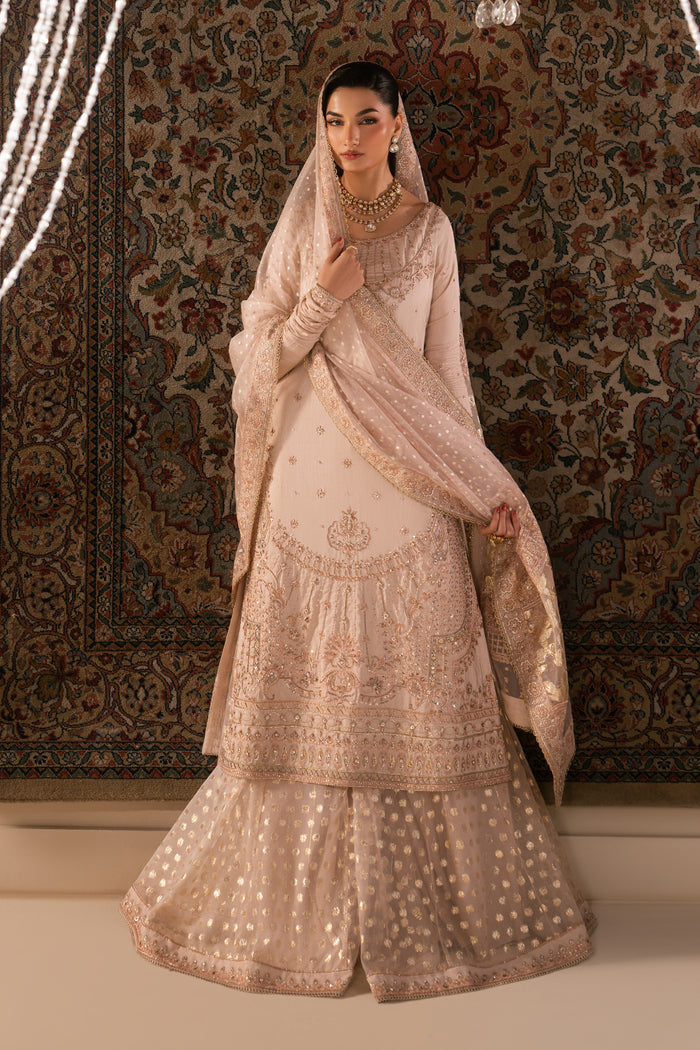 Bridal styling look of Mahbeer pale pink outfit with dupatta over head and flowing sharara, graceful ready made Nikkah wedding dress.