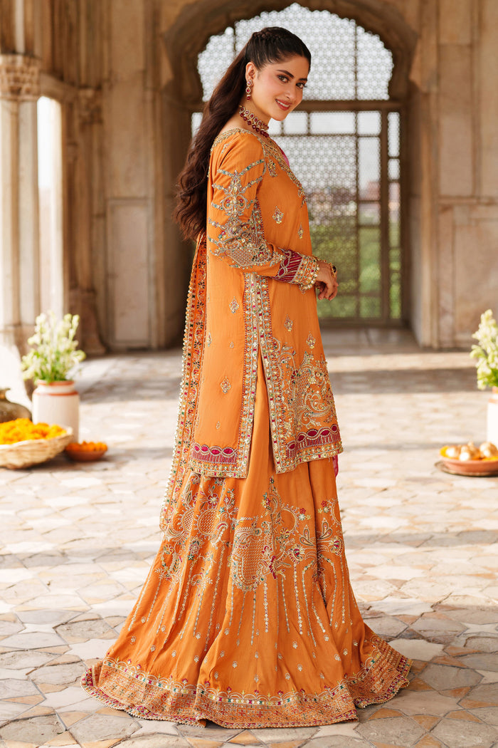 Side view of NAQSHI Mahzaeeb embroidered orange event dress with detailed sleeve work and coordinated sharara pants for wedding celebrations.
