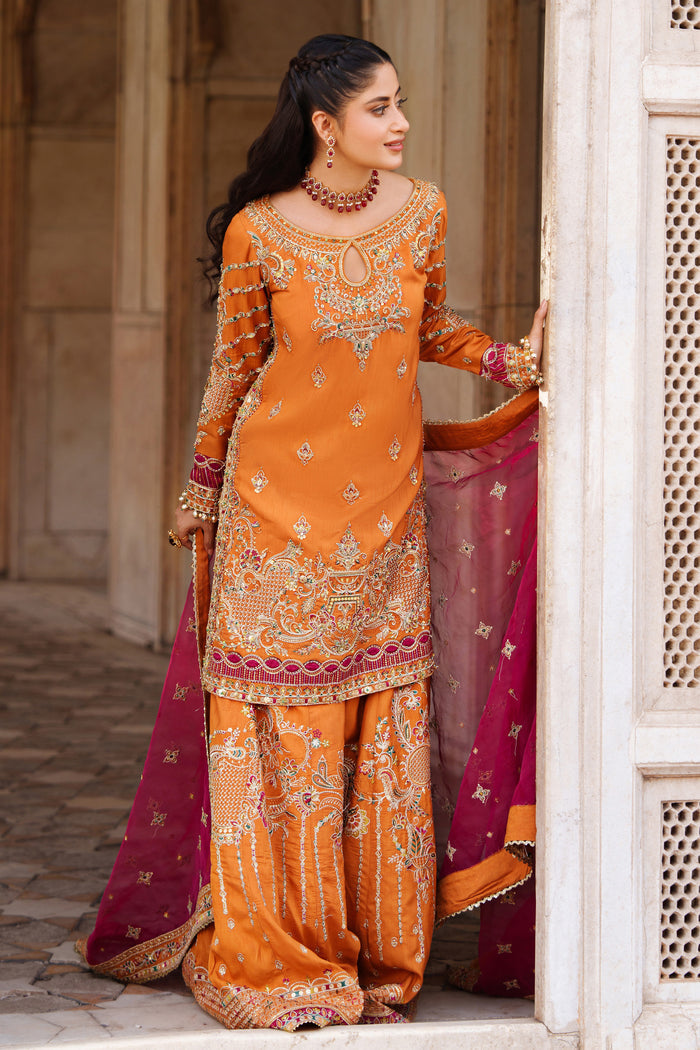 Full front pose of NAQSHI Mahzaeeb orange formal suit with pink embellished dupatta and ornate embroidery for wedding and party occasions.