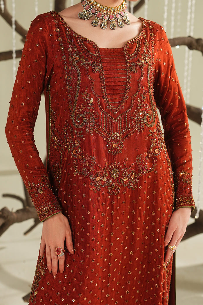 Close-up of rust orange formal shirt showing detailed embroidery, neckline design, and fine fabric texture