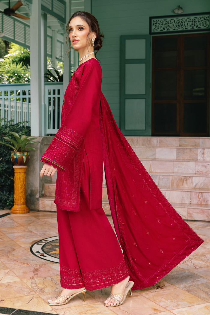 Woman in a red traditional outfit standing outdoors.