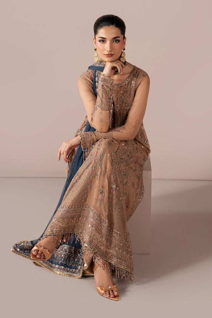 Seated view of Navira peach semi-formal outfit showing the embroidered shirt, flared pants and contrast Net dupatta.