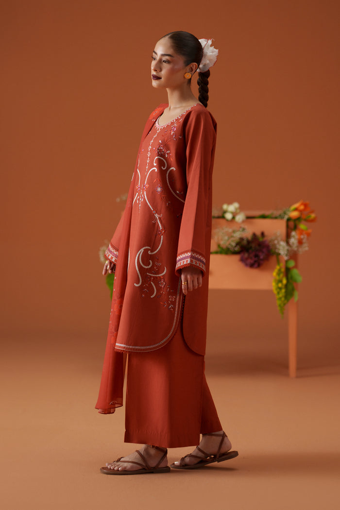 Side view of Ophelia rust ready-to-wear dress showing embroidered lawn shirt, wide culotte trouser, and soft printed dupatta.